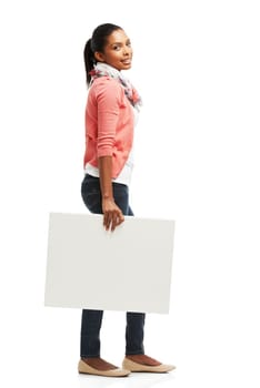 Carrying some copyspace. Casual young woman holding white copyspace against a white background.