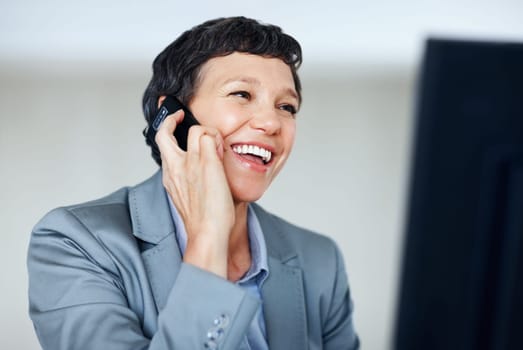 Female executive on phone. Cheerful mature female executive smiling while using cellphone.
