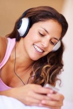 Listening to music. Smiling female listening to music on her mp3 player.