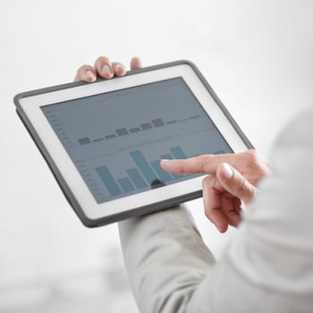 Cropped image of a businessman holding a digital tablet showing business data.