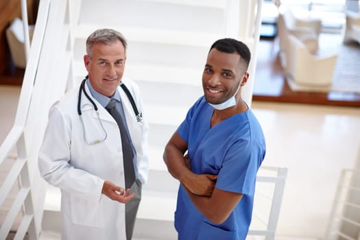 Share your health issues with us. Portrait of a confident doctor and surgeon standing in a medical suite.