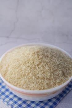 white long rice in a bowl on wooden background
