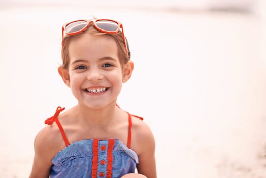 Who wants to go for a swim. Portrait of a smiling little girl at the beach.