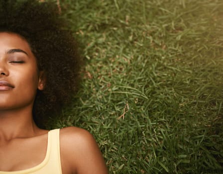 Sleep, grass and mockup with a black woman lying on a field from above for peace or quiet outdoor in nature. Dreaming, relax and zen with an attractive young female resting alone in the countryside