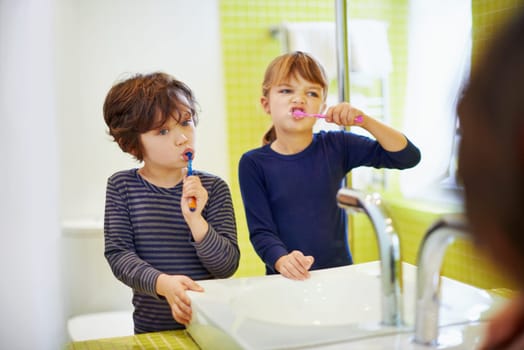 Children brushing teeth in home bathroom with toothbrush for hygiene and clean mouth. Oral healthcare or fresh breath, kids grooming while bonding and wellness with dental care at sink for dentist