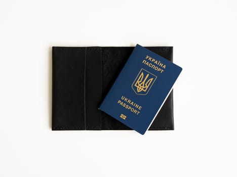 Ukrainian biometric passport id on a leather passport cover to travel the Europe without visas on the table. Inscription in Ukrainian Ukraine Passport.
