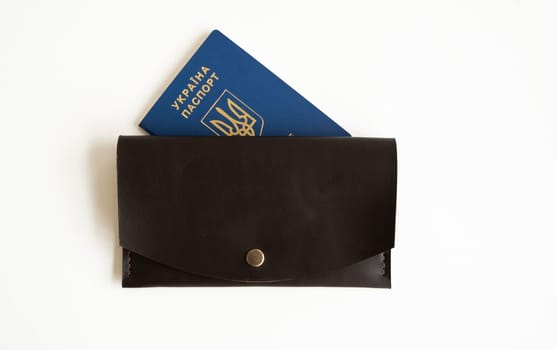 Ukrainian passport with a leather wallet on a white background.