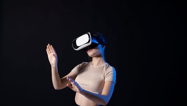 Woman in VR headset looking up at the objects in virtual reality while playing a game or watching 3d movie. Future technology concept.