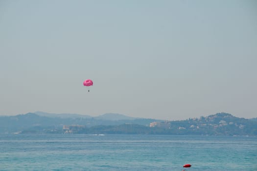 Parasailing at Beach in Europe, extreme Sport. Tourists parasailing, popular entertainment for holiday travelers on sea. Copy space