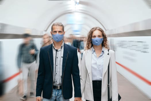man and a woman walking along the platform in subway .