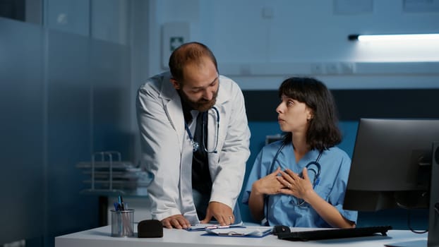 Medical staff looking at computer analyzing patient expertise while discussing medication treatment