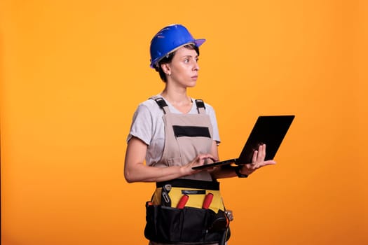 Focused construction worker holding wireless pc