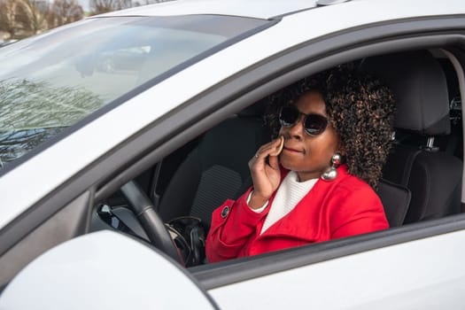 Pretty african american woman in a car doing makeup while standing in a traffic