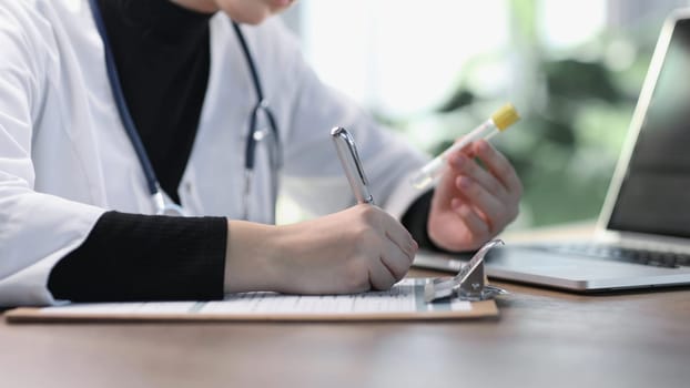 Female professional doctor hand making notes in medical journal.