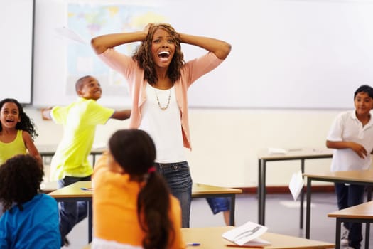 Stress, teacher shouting and black woman in classroom with children running around. Education, headache and female person screaming with burnout, tired or fatigue with kids in busy class at school.