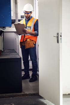 Man, technician and engineering with clipboard in control room, writing notes and machine maintenance. Male electrician, system and electrical substation for power, mechanic inspection and checklist