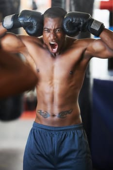 Every fibre in his body wants to fight. An african-american boxer with his fists against his head amping himself up for a fight.