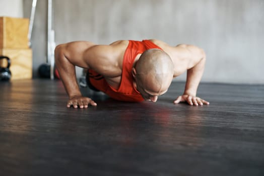 Fitness, floor exercise and man doing push up for strength workout, gym practice or bodybuilder training. Endurance challenge, discipline and strong male athlete doing studio exercises on ground