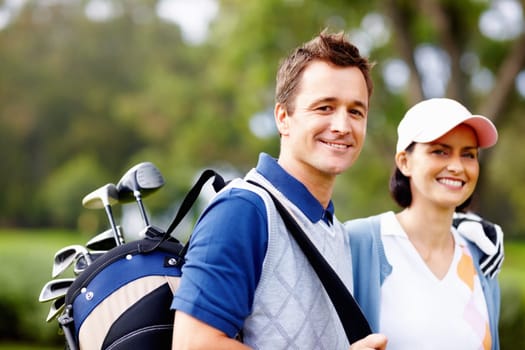 Couple smiling with man holding golf bag. Portrait of couple giving you a cute smile with man holding a golf bag.