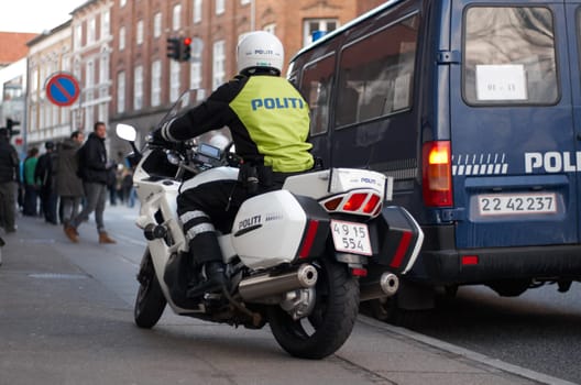 Emergency, motorbike and city safety police officer working for protection and peace in an urban town in Denmark. Security, law and legal professional or policeman on a motorcycle ready for service