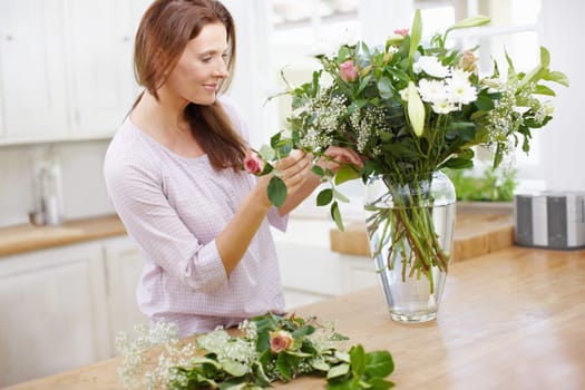 Arranging some fragrant flowers for the house. A beautiful woman woman arranging a fresh bouquet of flowers.