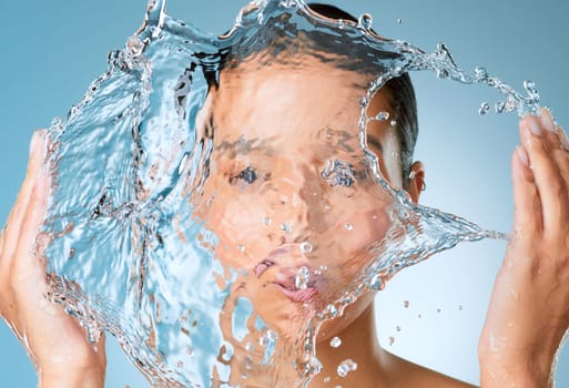 Pay attention to what your skin needs. an unrecognisable woman posing against a blue background in the studio and splashing her face with water.
