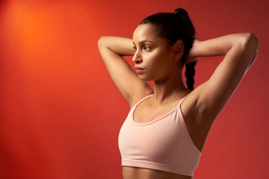 All it takes is a little discipline to get started. Studio shot of a sporty young woman stretching her arms against a red background.