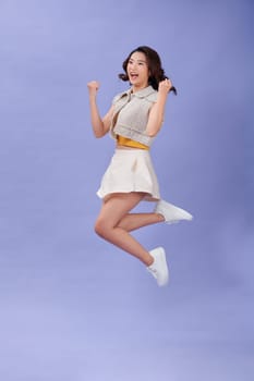 Photo of sweet lucky young woman jumping high rising arms smiling