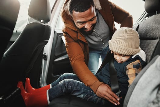 Father help child fasten seat belt leaving for vacation, trip or holiday in a car before travel together. Transport, transportation and dad or parent with kid in a vehicle for a getaway