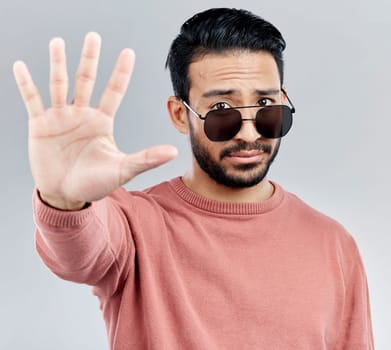 Stop, portrait and a cool man with sunglasses isolated on a white background in a studio. No, rejection and an Asian guy with a hand sign for warning, security and bouncer with decline on a backdrop