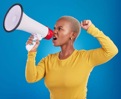 Megaphone, black woman and screaming in studio with fist of power, broadcast or vote on blue background. Speaker, microphone and girl protest for change, democracy or justice, noise or womens rights