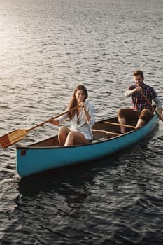 Enjoying their lakeside getaway. a young couple rowing a boat out on the lake.
