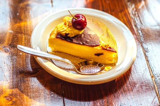 A delicious slice of cheesecake with chocolate topping and redcurrant
