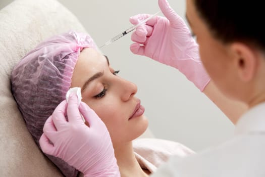 Cosmetologist performs the lift procedure by injecting beauty injections. Doctor injecting hyaluronic acid as facial rejuvenation treatment