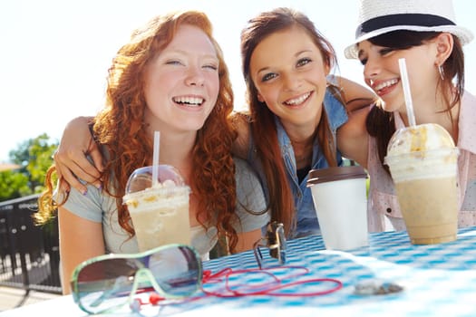 Building the bonds of friendship. A group of adolescent girls enjoying smoothies at an outdoor cafe.