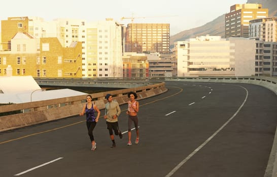 The streets are all ours. joggers running down an empty highway in the morning.