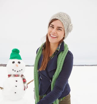It was love at first sight for the snowman. a gorgeous young woman walking passed a snowman.