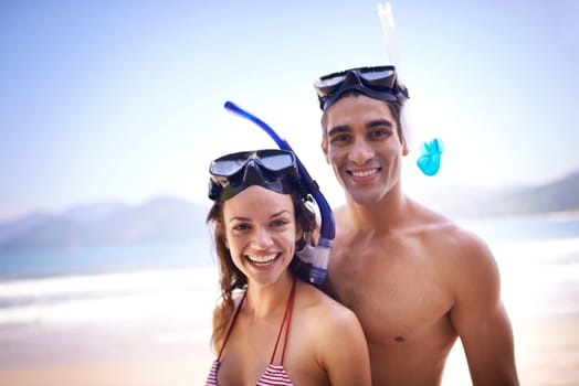 Lets get down. a happy young couple in snorkeling gear at the beach.