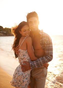 Holding her close. a young couple enjoying a beach getaway.