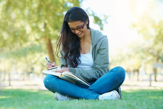 Preparing for exams. A student studying her textbook in the park.
