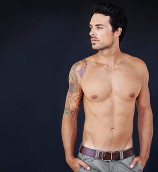 Thinking, mockup and shirtless with a sexy man in studio on a dark background for masculine desire. Idea, tattoo and aesthetic with a handsome young male model posing topless for manly sensuality