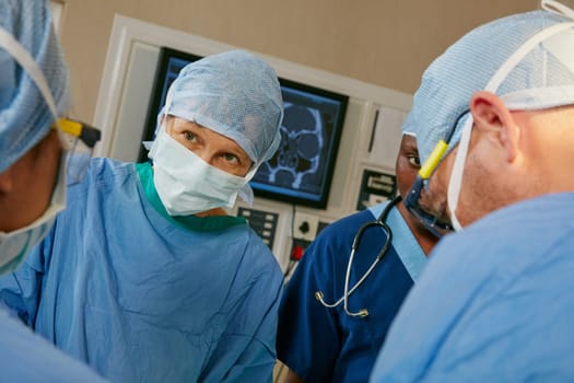 Performing a successful surgery through effective teamwork. a team of surgeons performing a surgery in an operating room.