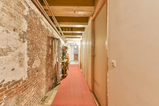 a hallway with brick walls and a pink carpet
