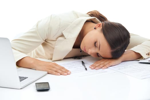 Overworked and overwhelmed. A young businesswoman asleep at her desk crowded with work isolated on a white background.