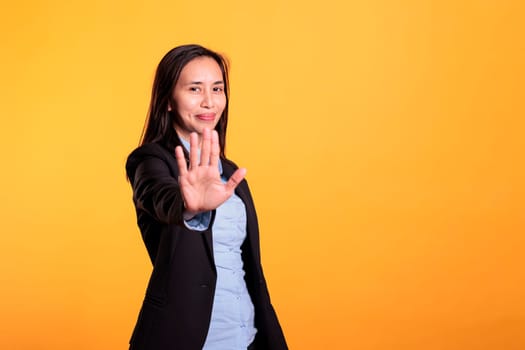 Negative filipino businesswoman doing stop gesture with hand