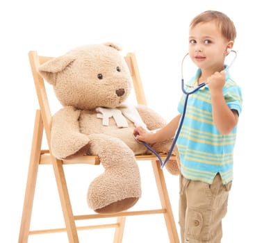 Playing doctor. Studio shot of a young boy playing with his teddy bear and a stethoscope.