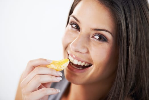 Bursting with citrus delight. Portrait of an attractive young woman eating fruit.