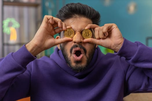 Indian man stock trader earning bitcoins, online monitoring trading operations mining hold BTC coins
