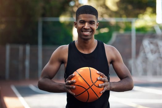 Talent is a big factor in the game. Portrait of a sporty young man standing on a basketball court.