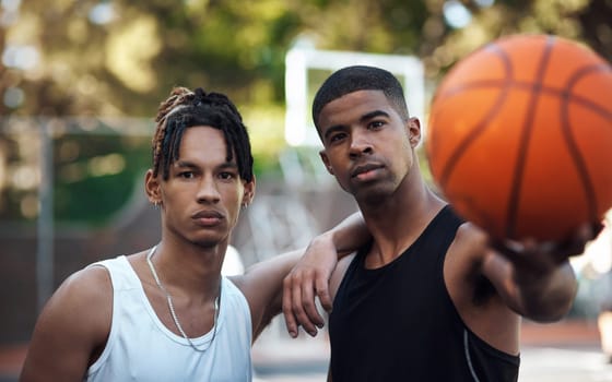 Becoming NBA stars of their own. Portrait of two sporty young men standing on a basketball court.